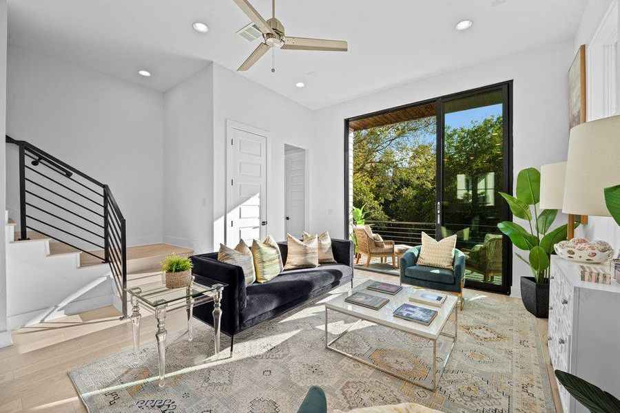 Living area featuring light wood-style floors, recessed lighting, stairway, and ceiling fan Living area featuring light wood-style floors, recessed lighting, stairway, and ceiling fan