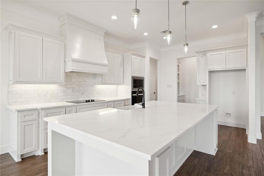 Kitchen featuring white cabinetry, dark hardwood / wood-style flooring, an island with sink, and sink