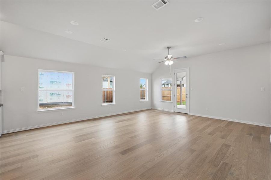 Unfurnished room featuring lofted ceiling, light wood-style floors, and ceiling fan