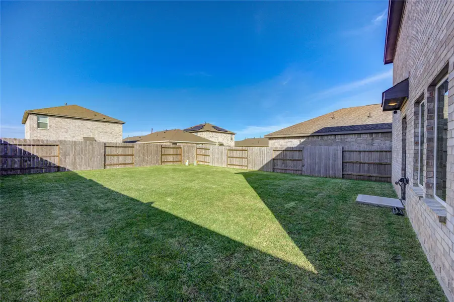 Spacious, fenced backyard with well-maintained lawn, perfect for outdoor activities and privacy.