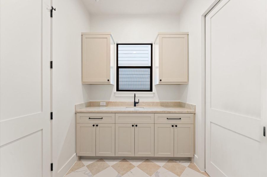 Laundry room, adjacent to the primary closet, offers utility sink and mosaic tile floors. Laundry room, adjacent to the primary closet, offers utility sink and mosaic tile floors.