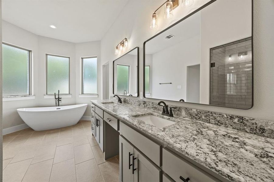 Bathroom with double vanity, a stall shower, a freestanding tub, light tile patterned floors, and recessed lighting Bathroom with double vanity, a stall shower, a freestanding tub, light tile patterned floors, and recessed lighting