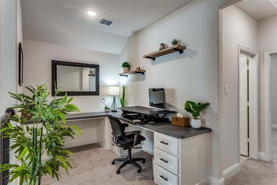 Office area featuring light colored carpet and vaulted ceiling Office area featuring light colored carpet and vaulted ceiling