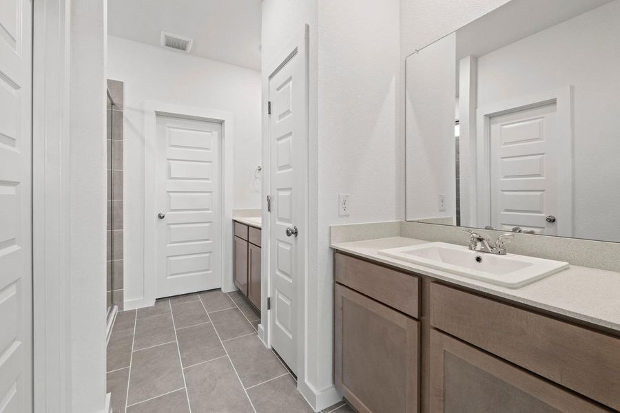 A well-appointed bathroom offers sleek counters and ample storage in a light, neutral palette. A well-appointed bathroom offers sleek counters and ample storage in a light, neutral palette.