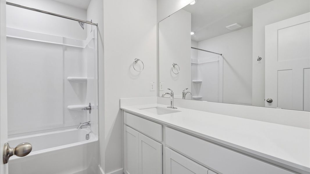 Vibrant and welcoming bathroom with elegant countertop space and polished details by DRB Homes Vibrant and welcoming bathroom with elegant countertop space and polished details by DRB Homes