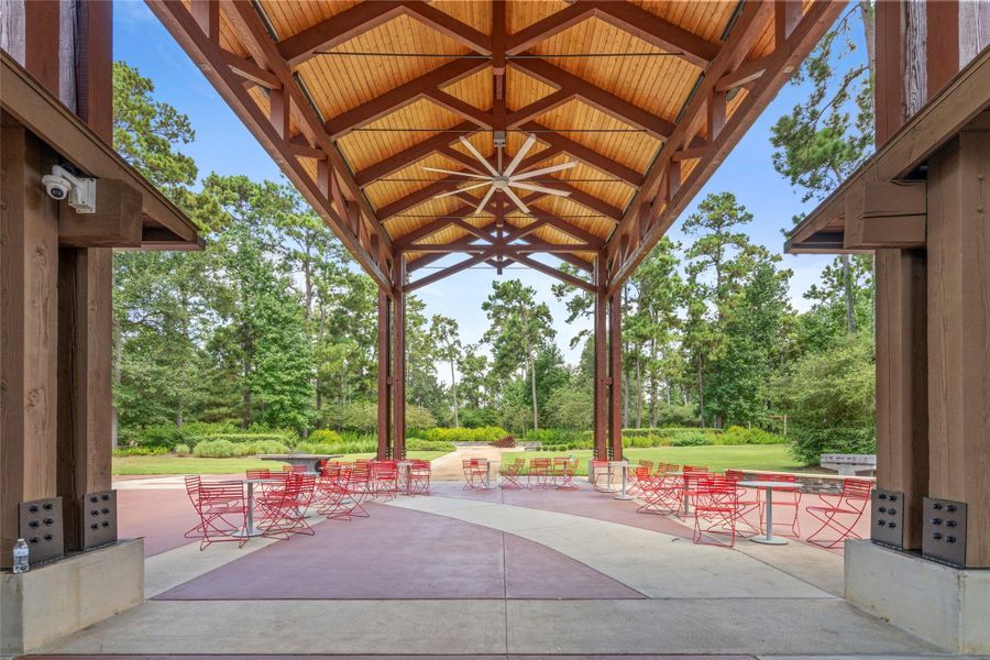 Covered community pavilion and outdoor gathering area surrounded by trees at The Groves.