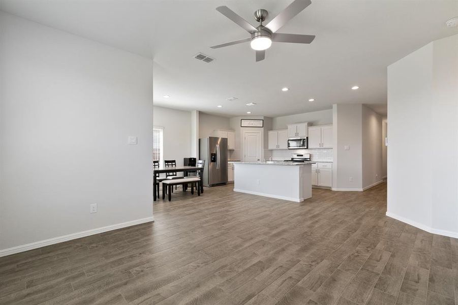 Living room featuring recessed lighting, dark wood-type flooring, and a ceiling fan