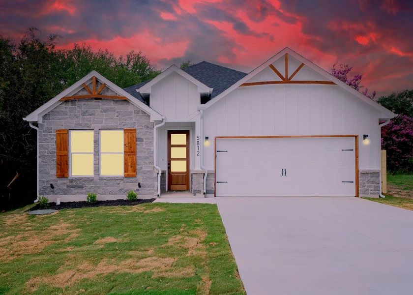 View of front of home with a garage and a yard