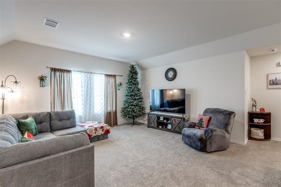 Living room featuring vaulted ceiling and carpet flooring Living room featuring vaulted ceiling and carpet flooring