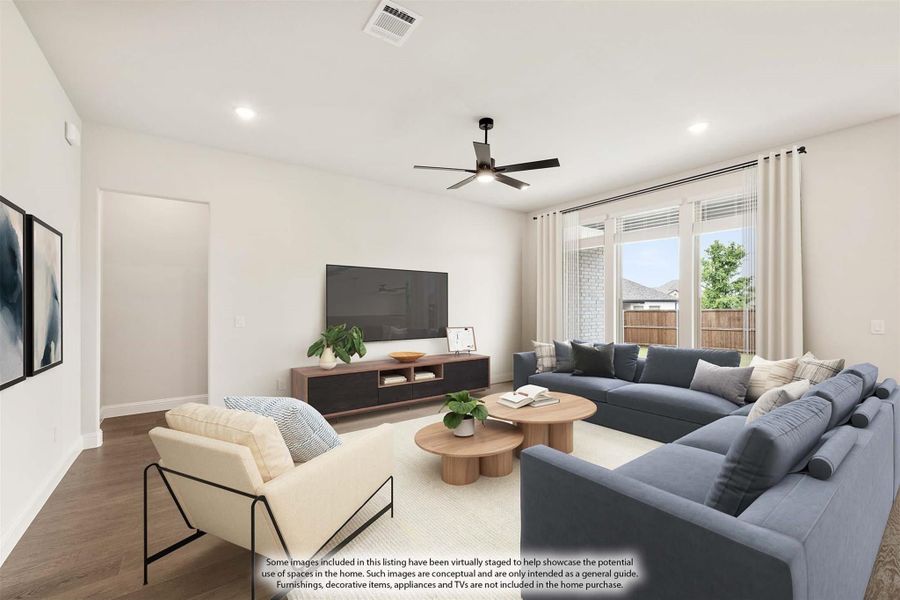 Living room with gray sectional sofa, hardwood floors, ceiling fan, and large windows with natural light Living room with gray sectional sofa, hardwood floors, ceiling fan, and large windows with natural light