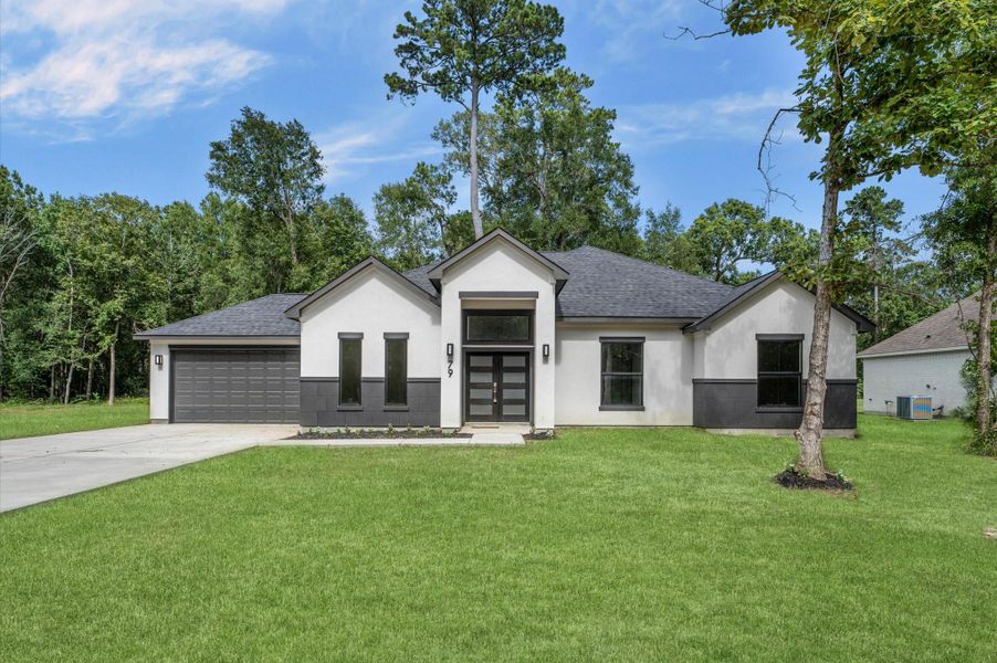 This modern, single-story home features a sleek black and white exterior, a spacious driveway, and a two-car garage. It is set on a lush green lawn with surrounding trees, offering a serene and private atmosphere. This modern, single-story home features a sleek black and white exterior, a spacious driveway, and a two-car garage. It is set on a lush green lawn with surrounding trees, offering a serene and private atmosphere.