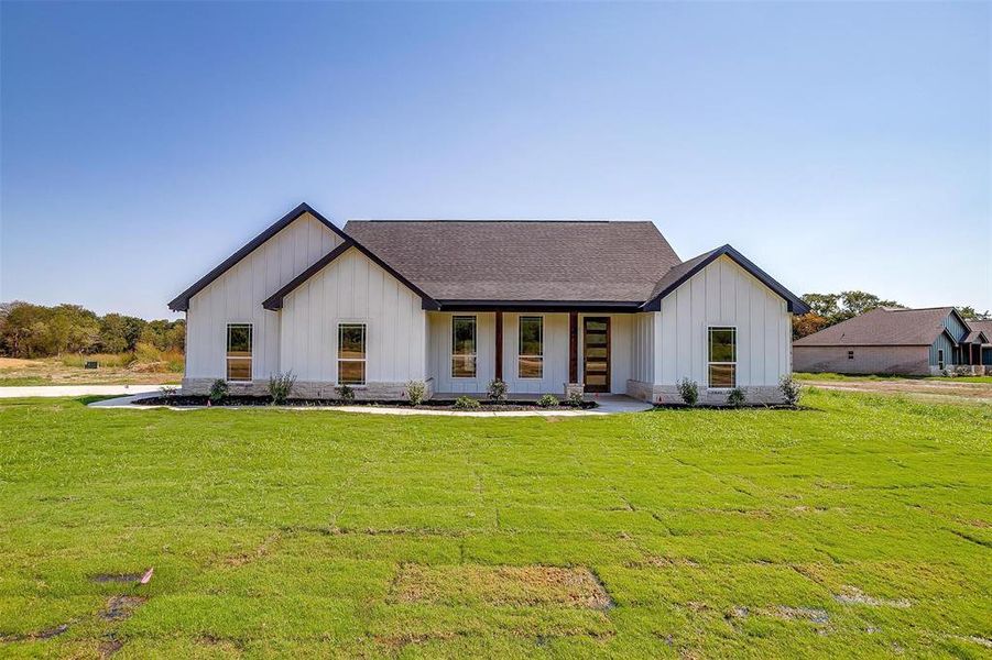 Modern farmhouse style home with a front yard