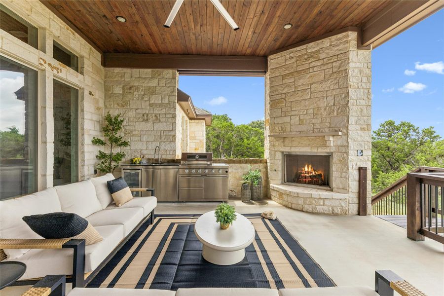 An inviting covered patio offers a complete outdoor kitchen and a cozy fireplace, perfect for alfresco living.