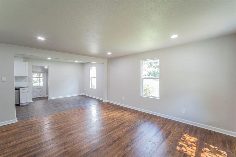 lLiving room with a healthy amount of sunlight and dark wood-type flooring