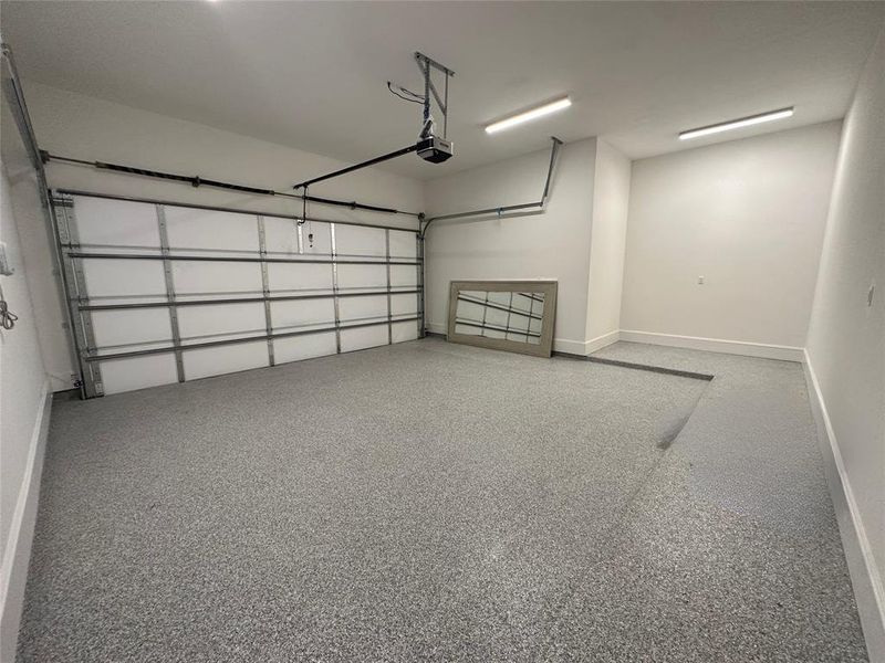 Garage interior finished with epoxy flooring and insulated cedar garage door