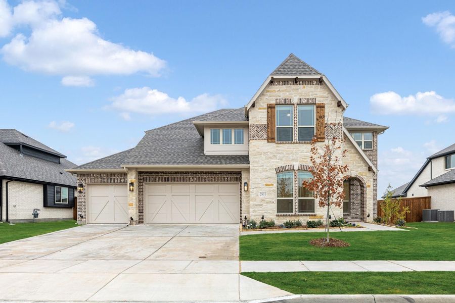 Two-story home with stone and brick exterior, three-car garage, and arched front entry Two-story home with stone and brick exterior, three-car garage, and arched front entry