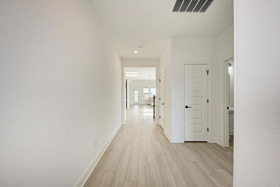 Corridor with light wood finished floors and recessed lighting