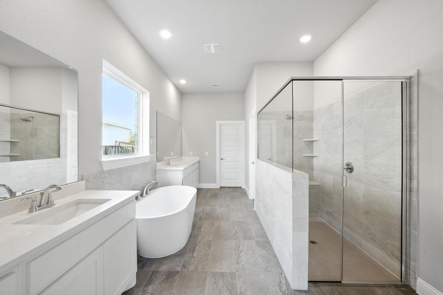 Full bath with a shower stall, two vanities, a soaking tub, and recessed lighting Full bath with a shower stall, two vanities, a soaking tub, and recessed lighting