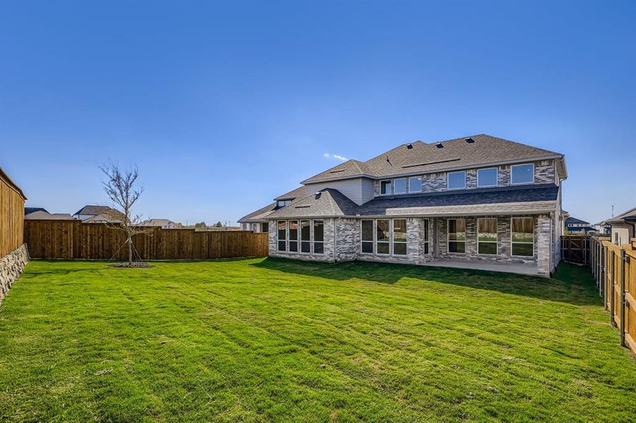 Back of property with a fenced backyard, a patio, roof with shingles, and brick siding Back of property with a fenced backyard, a patio, roof with shingles, and brick siding