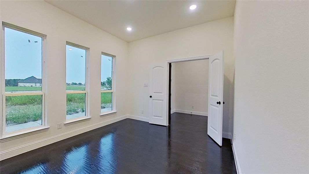 Empty room featuring dark wood-type flooring and recessed lighting Empty room featuring dark wood-type flooring and recessed lighting