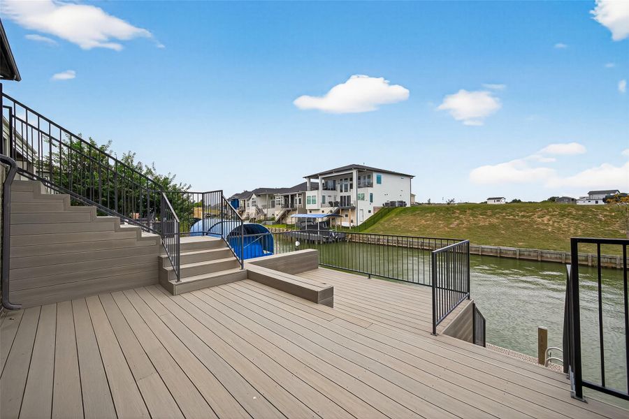 Expansive lower deck with sleek iron railings offering a seamless connection between the home and the lakefront. Expansive lower deck with sleek iron railings offering a seamless connection between the home and the lakefront.