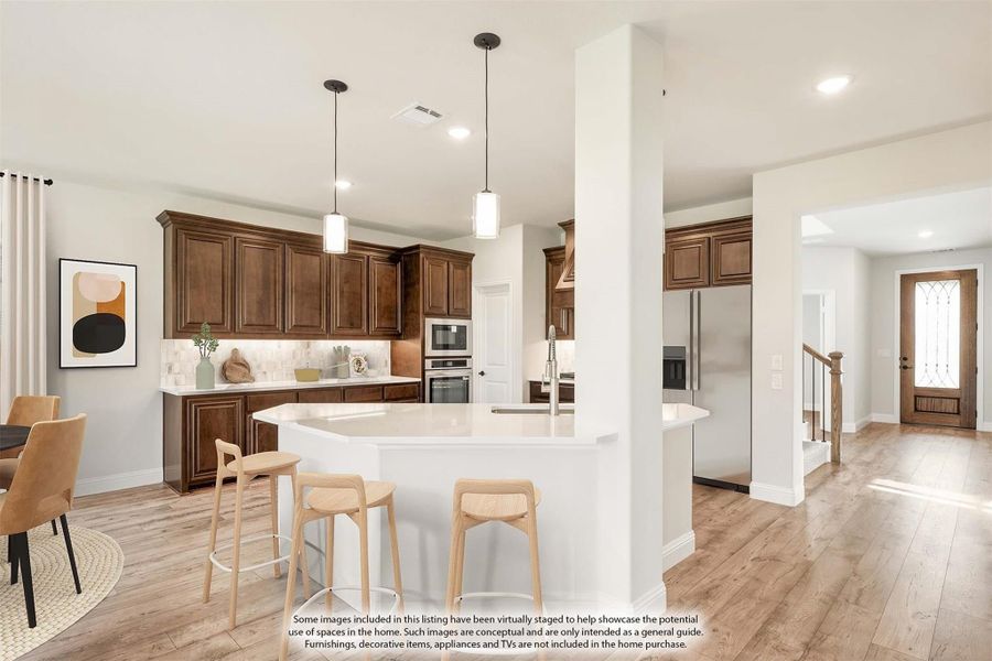 Kitchen with dark wood cabinets, white island with bar stools, pendant lights, and stainless steel appliances on light hardwood floors