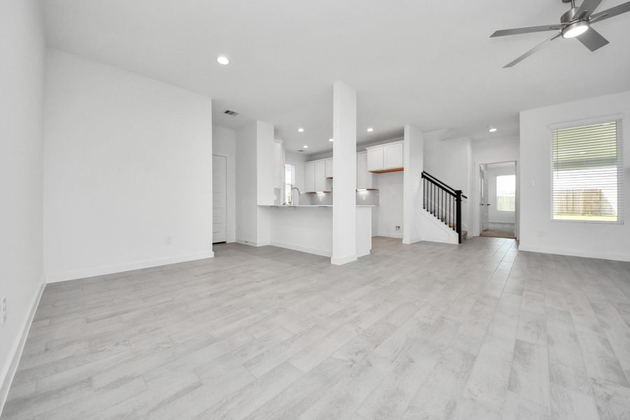Create lasting memories with your family and friends at the dining table! This expansive dining room showcases sophisticated flooring, custom paint, and seamlessly connects to the family room and kitchen, providing an open and inviting atmosphere. Sample photo of completed home with similar floor plan. Actual colors and selections may vary.