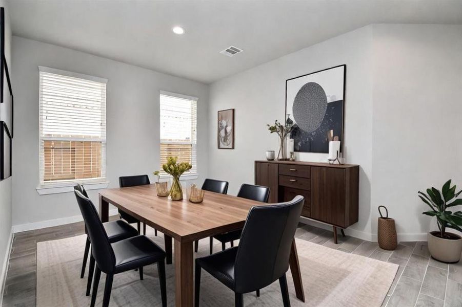 Craft enduring memories with loved ones around the table in this roomy dining area. It boasts stylish flooring, personalized paint, and is conveniently situated next to the family room and kitchen, fostering an open and inclusive ambiance.  Sample photo of completed home with similar plan. As built color and selections may vary.