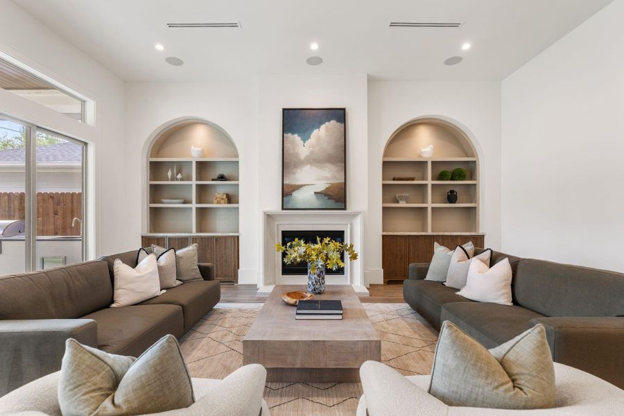 The main hallway transitions effortlessly from the entry into the heart of the home, showcasing continuous hardwood flooring, soft neutral tones, and an open layout that connects formal and casual living areas.