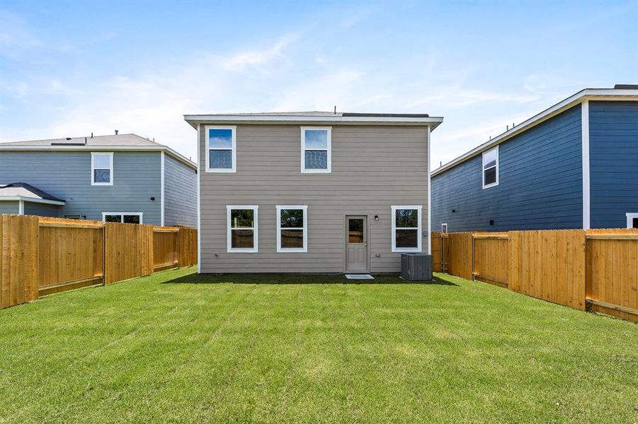 Rear view of property featuring a yard and cooling unit