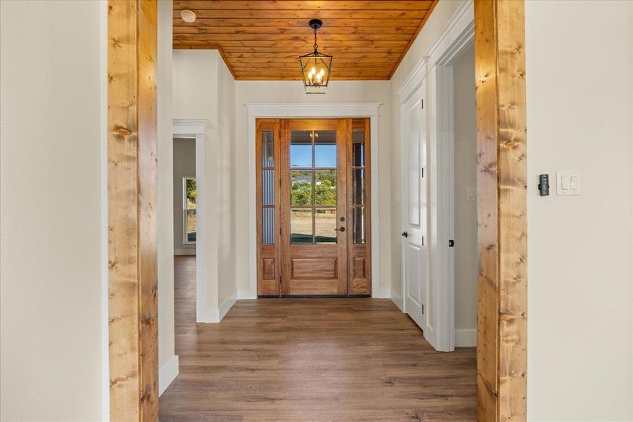 Foyer featuring wooden ceiling, wood finished floors, and a chandelier