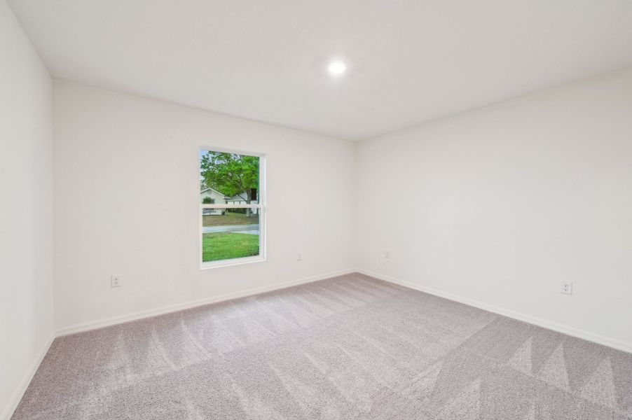 A room with a carpet and a window.