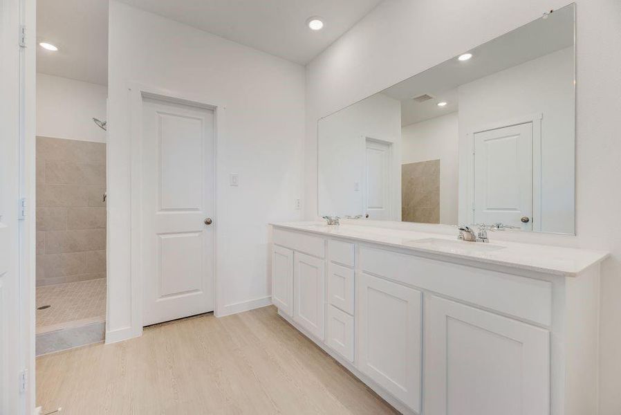 Bathroom with walk in shower, double vanity, wood finished floors, and recessed lighting Bathroom with walk in shower, double vanity, wood finished floors, and recessed lighting