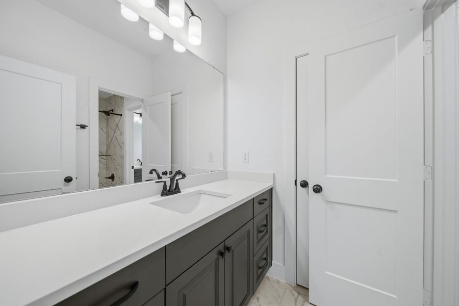 Located just off the secondary bedrooms, this full bathroom offers additional privacy with separated vanity areas and shower making it easy to share and get ready.