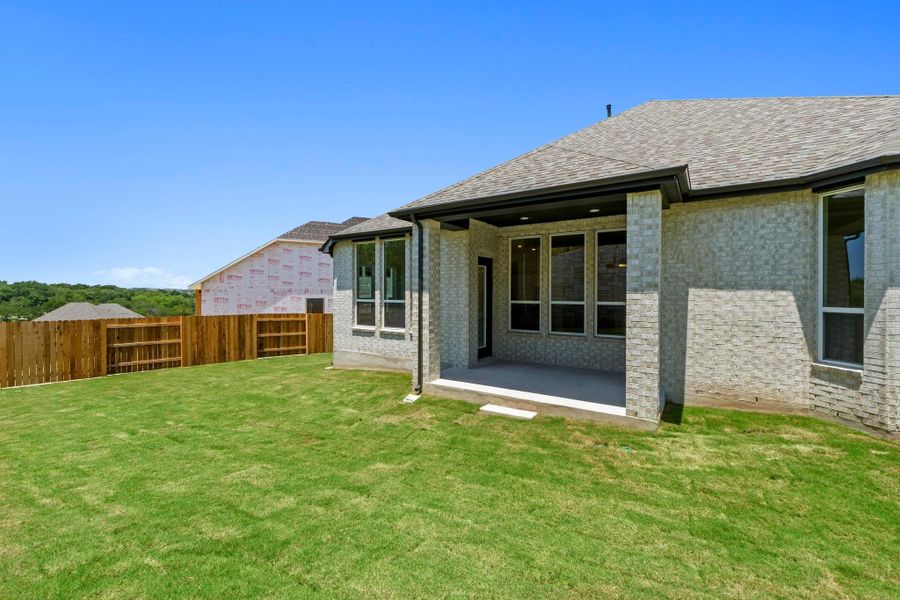 Back of house with brick siding, a patio area, and a shingled roof