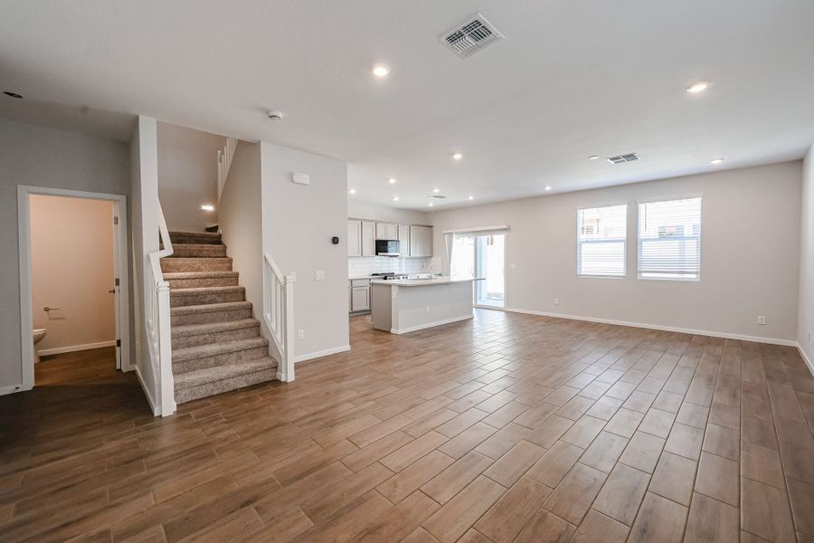 A large empty room with a wood floor and white walls.