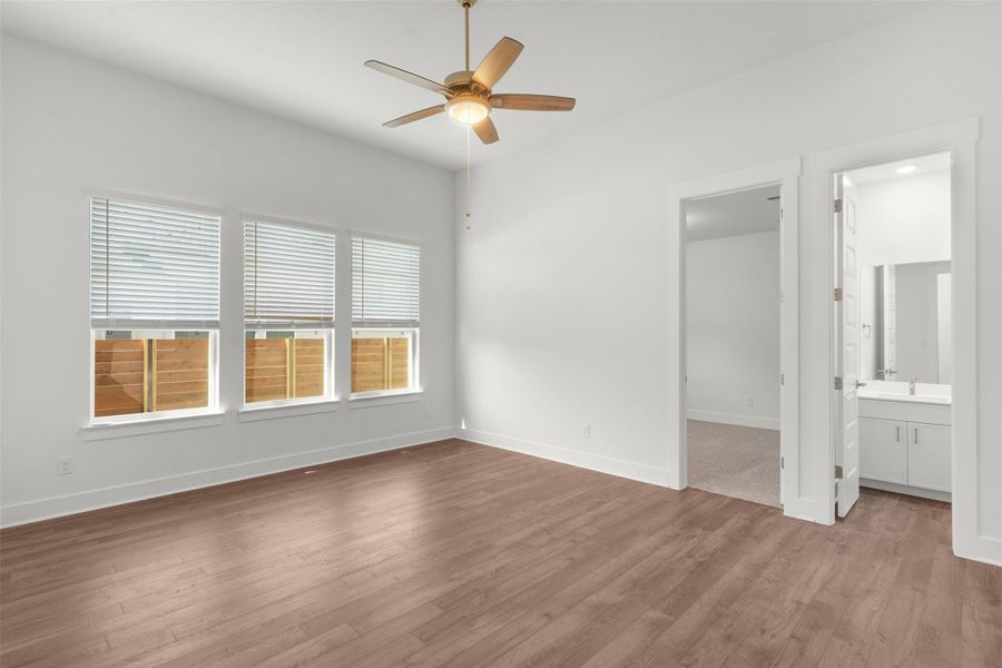 Unfurnished bedroom with dark wood finished floors, a ceiling fan, and ensuite bathroom