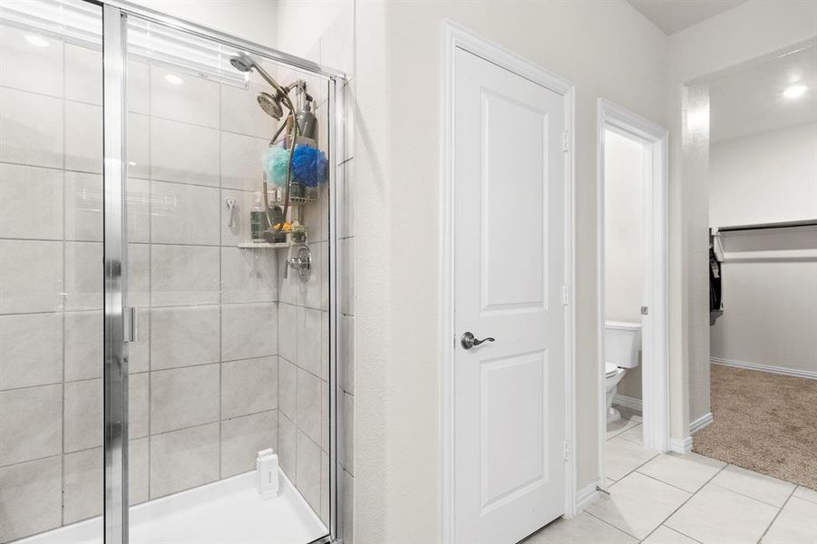 Full bath with a shower stall and tile patterned flooring Full bath with a shower stall and tile patterned flooring