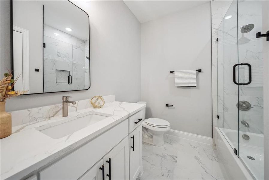 Full bathroom with toilet, combined bath / shower with glass door, and vanity