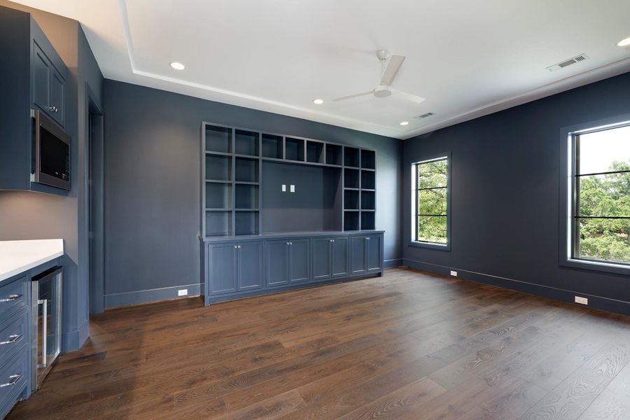 This flexible space on the 2nd floor can be used as a media room or a game room. Wet bar area to the left.