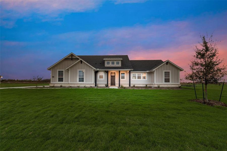 View of front of home featuring a porch, a shingled roof, board and batten siding, and a front lawn