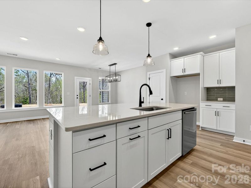 42" White cabinets, Quartz countertops, tiled backsplash. Large kitchen island with shiplap accent, Frigidaire Appliances. Cooking is exhaust vented to the outside