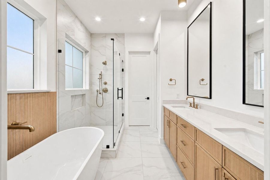 Primary bathroom featuring dual sinks, a soaking tub and a shower.