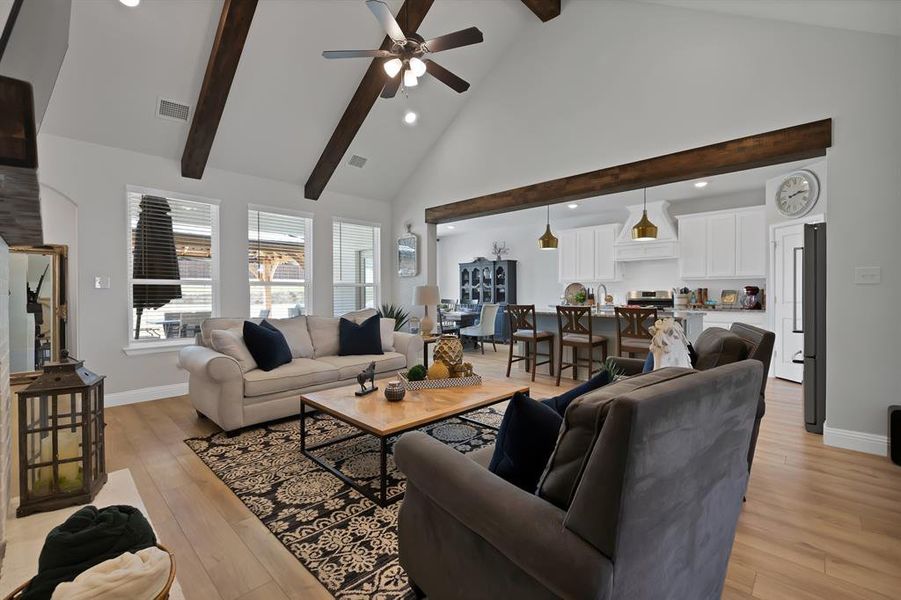 Living area featuring recessed lighting, high vaulted ceiling, light wood-type flooring, ceiling fan, and beamed ceiling Living area featuring recessed lighting, high vaulted ceiling, light wood-type flooring, ceiling fan, and beamed ceiling