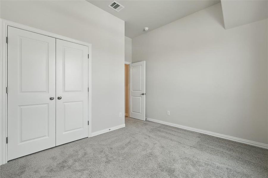 Unfurnished bedroom with carpet floors and a closet Unfurnished bedroom with carpet floors and a closet