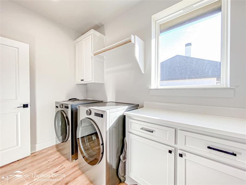 Utility room with full-size washer and dryer hook ups, folding space, additional storage, and a large picture window with natural light!
