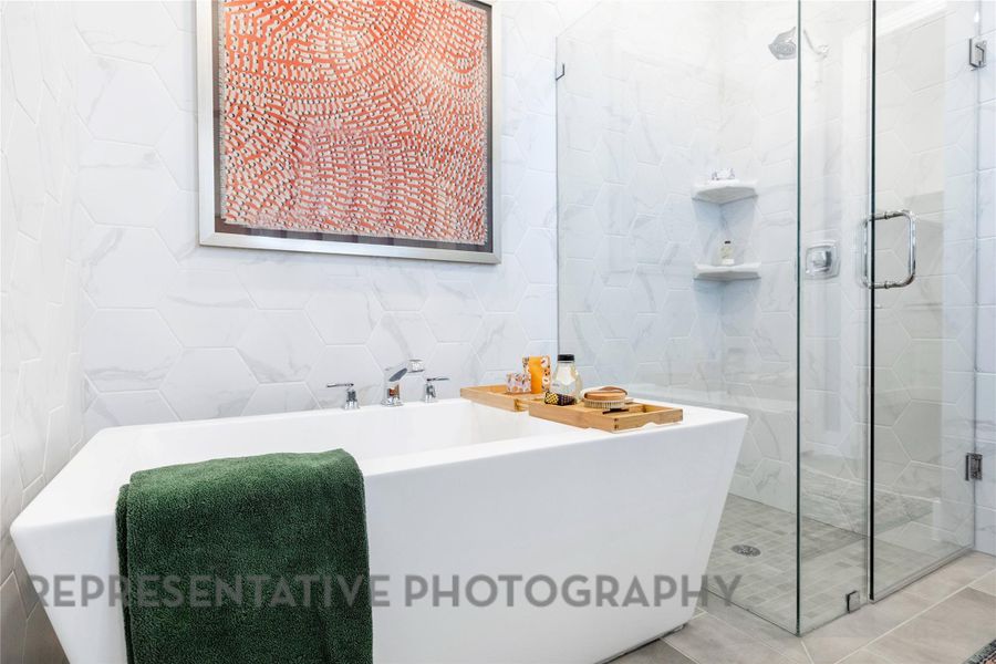 Full bath featuring tile walls, a shower stall, and a freestanding tub Full bath featuring tile walls, a shower stall, and a freestanding tub