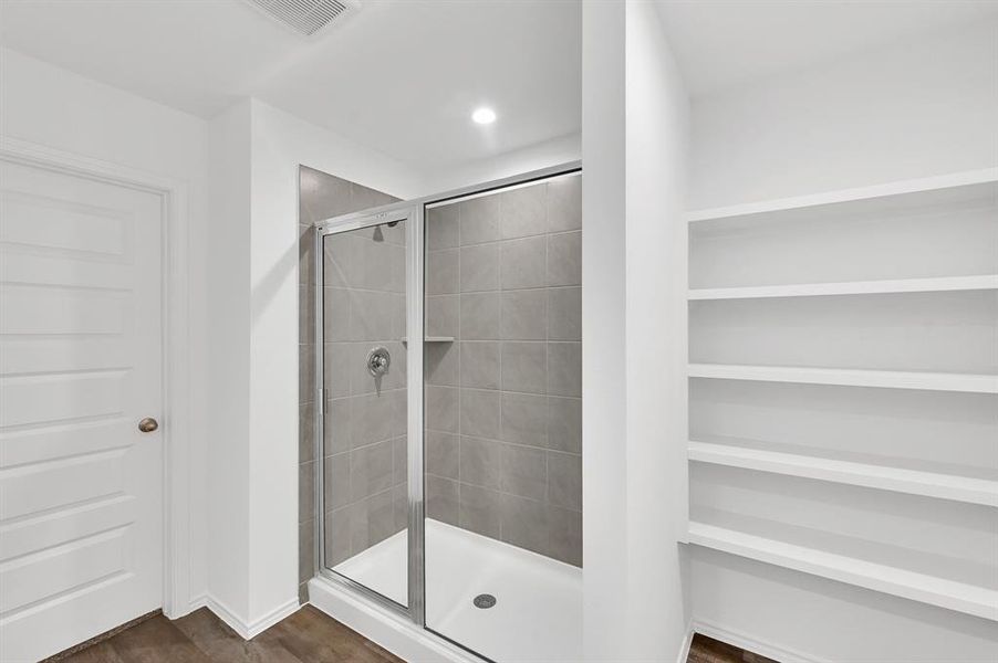 The primary bathroom offers ample storage space, and the shower area is generously sized for added comfort and convenience.