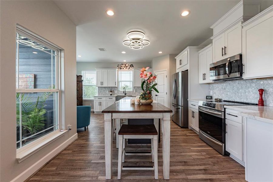 The stunning kitchen is a chef's dream, featuring a large island with plenty of prep space, high-end finishes, and modern appliances.