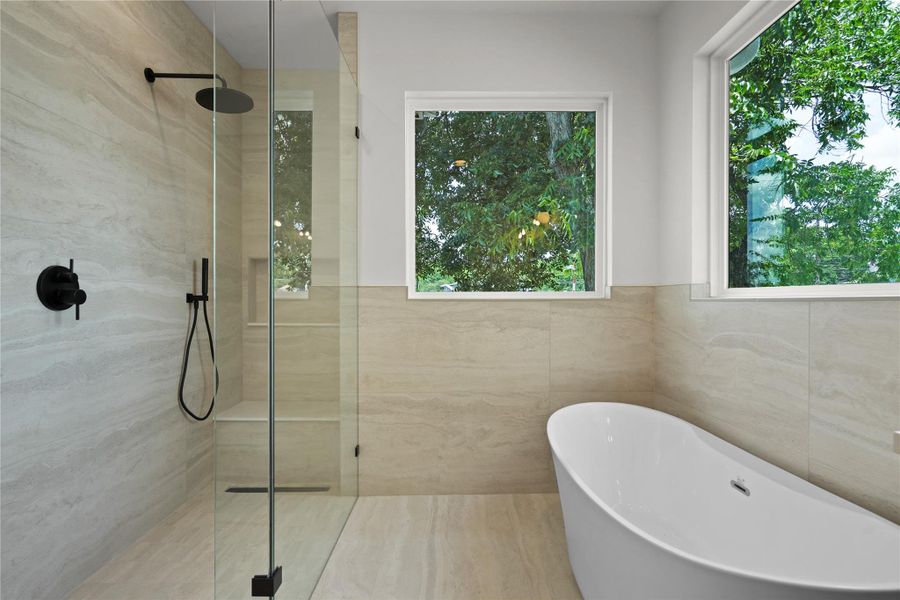 Indulge in a tranquil bathing experience with a free-standing tub and oversized shower.